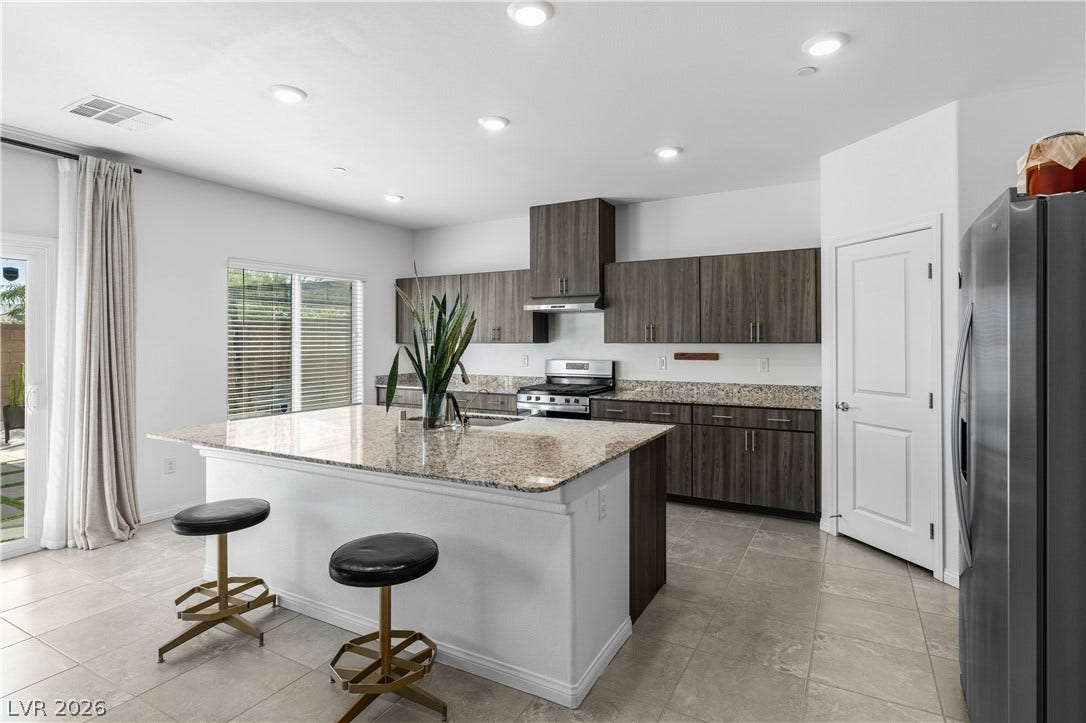4429 Ginger Hills Avenue, Las Vegas, NV 89141 Polished stone countertops pair with contemporary cabinetry in this airy open-concept kitchen.