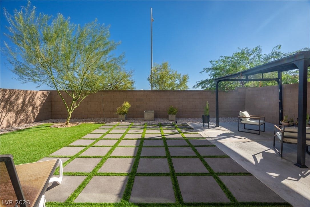 4429 Ginger Hills Avenue, Las Vegas, NV 89141 Geometric paver design highlights this manicured backyard under open blue skies.