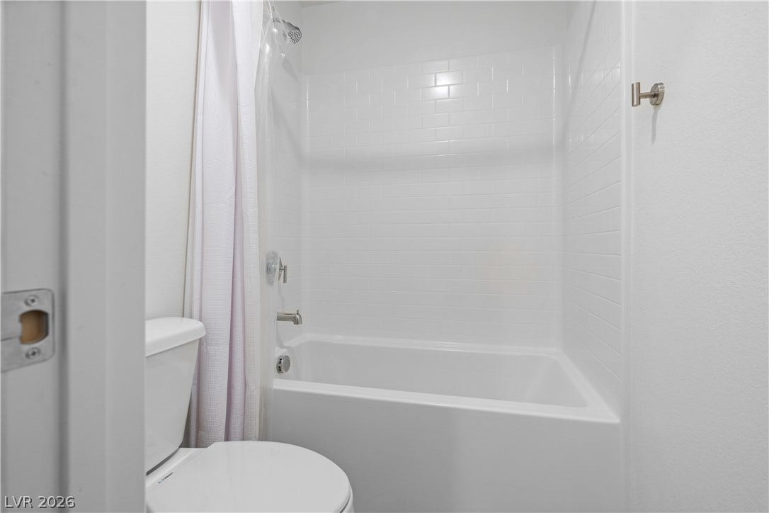 4429 Ginger Hills Avenue, Las Vegas, NV 89141 Crisp white subway tiles surround a clean tub and shower combination.