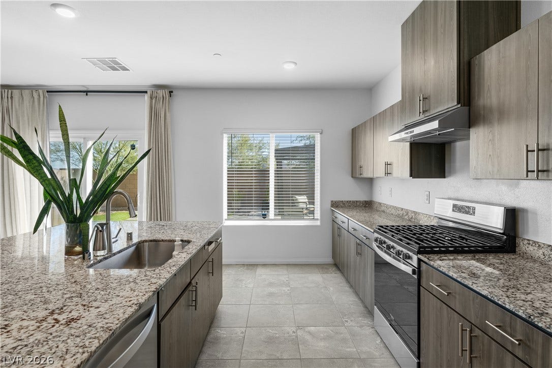 4429 Ginger Hills Avenue, Las Vegas, NV 89141 Polished granite countertops complement contemporary cabinetry and modern appliances in this spacious kitchen.