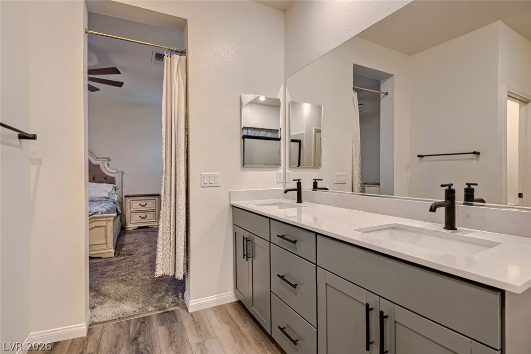 A modern double vanity with stone counters seamlessly integrates into this spacious layout.