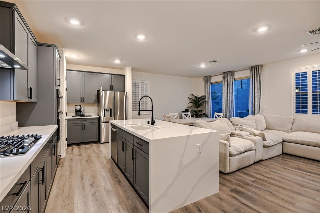 Gleaming quartz countertops pair with sleek cabinetry in this modern open concept layout.