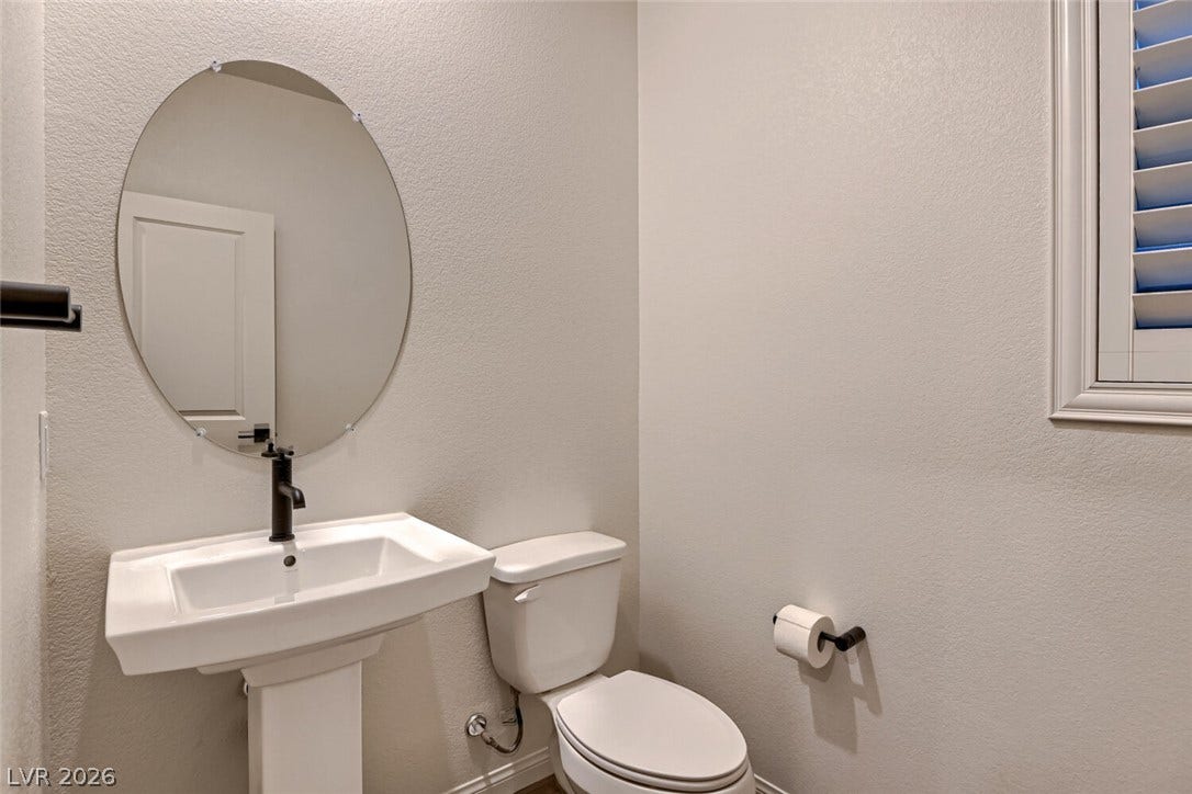 A classic pedestal sink and clean lines define this modern powder room.