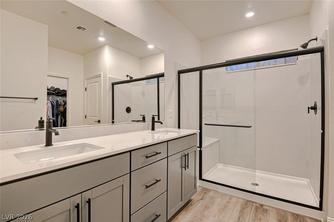 A spacious vanity and sliding glass shower doors highlight this modern bathroom design.