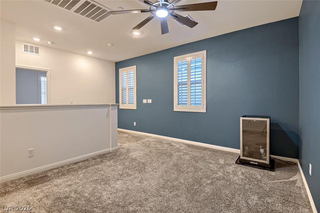 Plush carpeting and plantation shutters highlight this versatile upper level loft space.