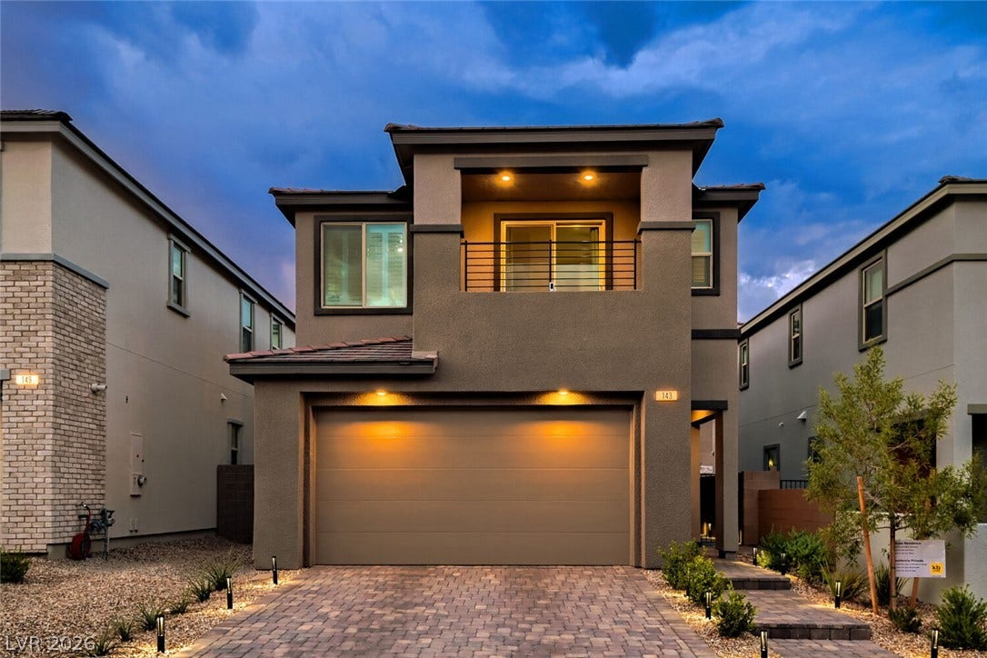 Modern architecture defines this two-story home, showcasing a paved driveway and structured upper-level balcony.