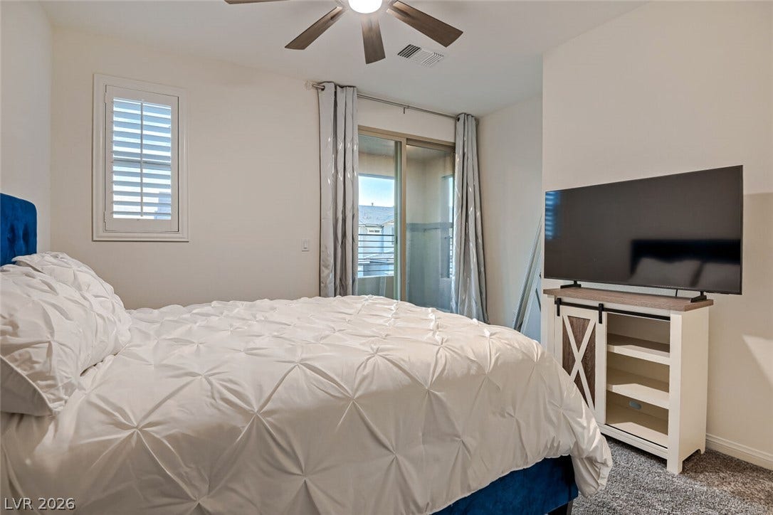Sliding glass doors open directly to a private balcony from this carpeted bedroom.