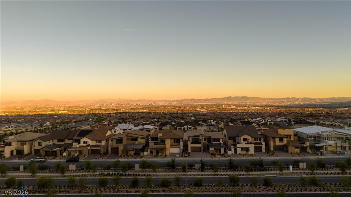 Distant mountains frame a sprawling neighborhood captured under a warm sunset glow.