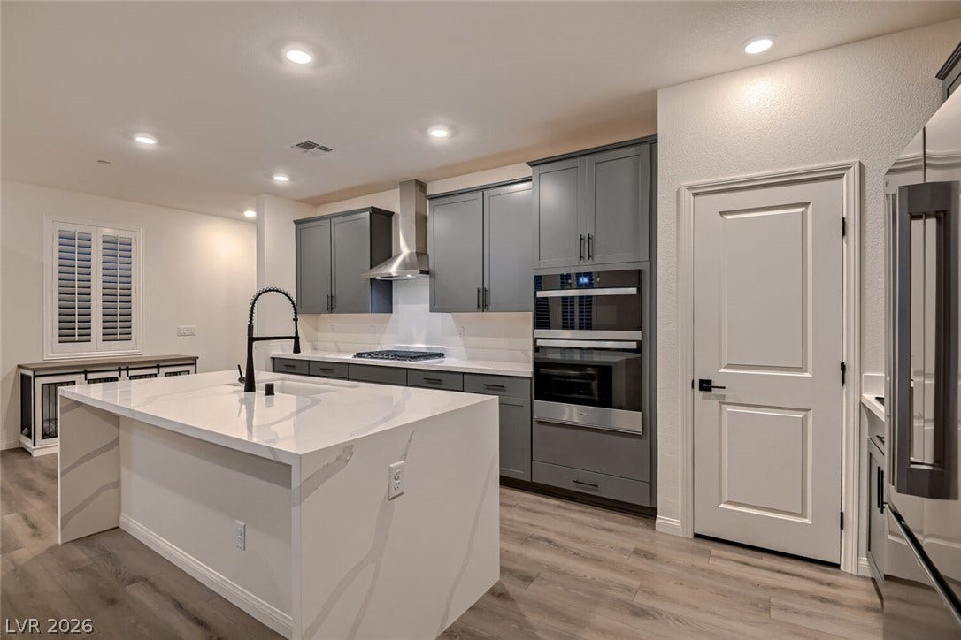 Sleek cabinetry and a large waterfall island anchors this modern kitchen workspace.