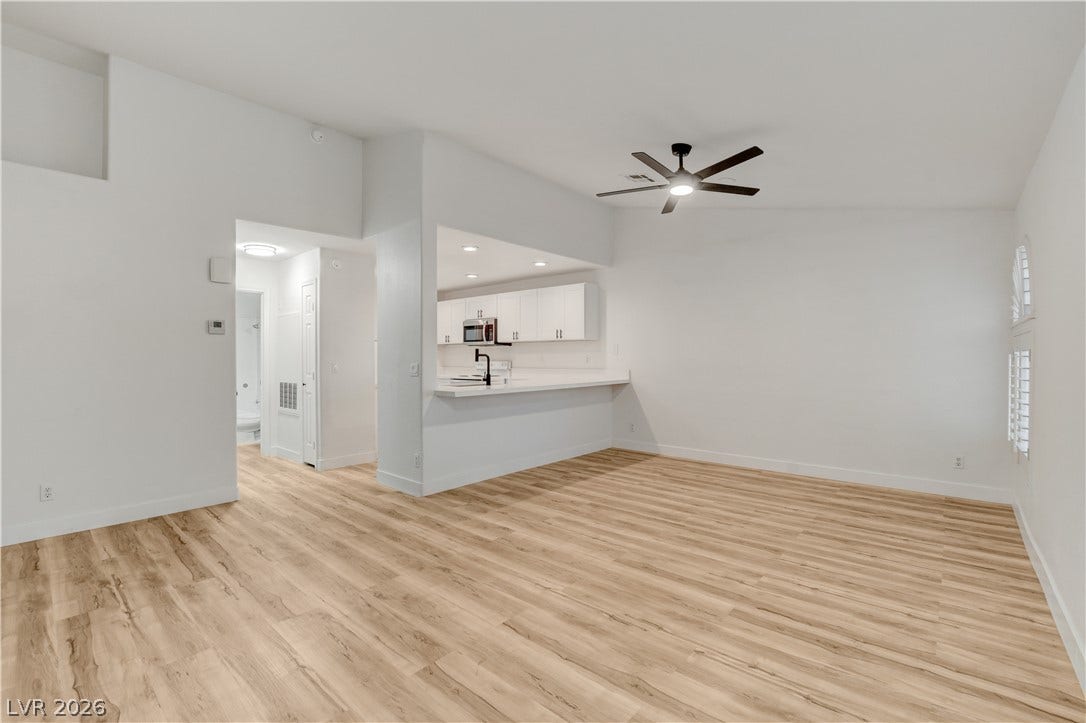 3676 Renovah Street, #205, Las Vegas, NV 89129 Gleaming wood-look floors anchor this airy living space opening directly into the modern kitchen.