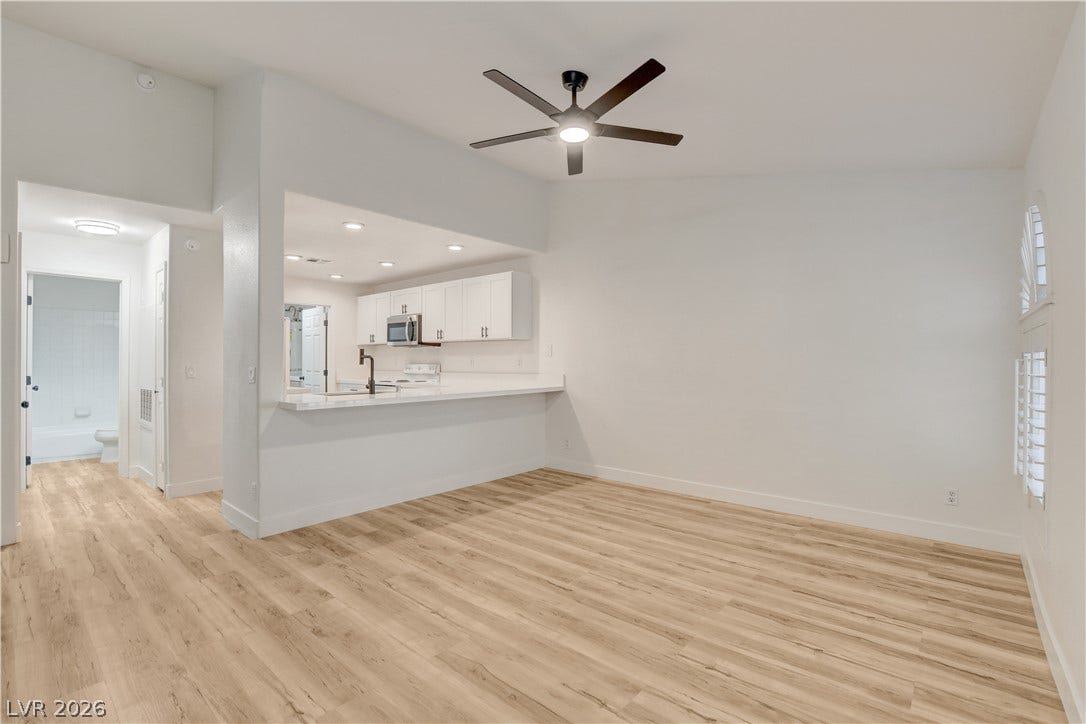 3676 Renovah Street, #205, Las Vegas, NV 89129 An open floor plan connects the main living space to the kitchen over smooth wood-style flooring.