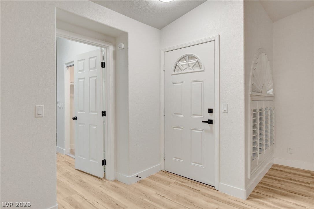 3676 Renovah Street, #205, Las Vegas, NV 89129 Smooth plaster walls and light wood-tone flooring define this welcoming entryway space.