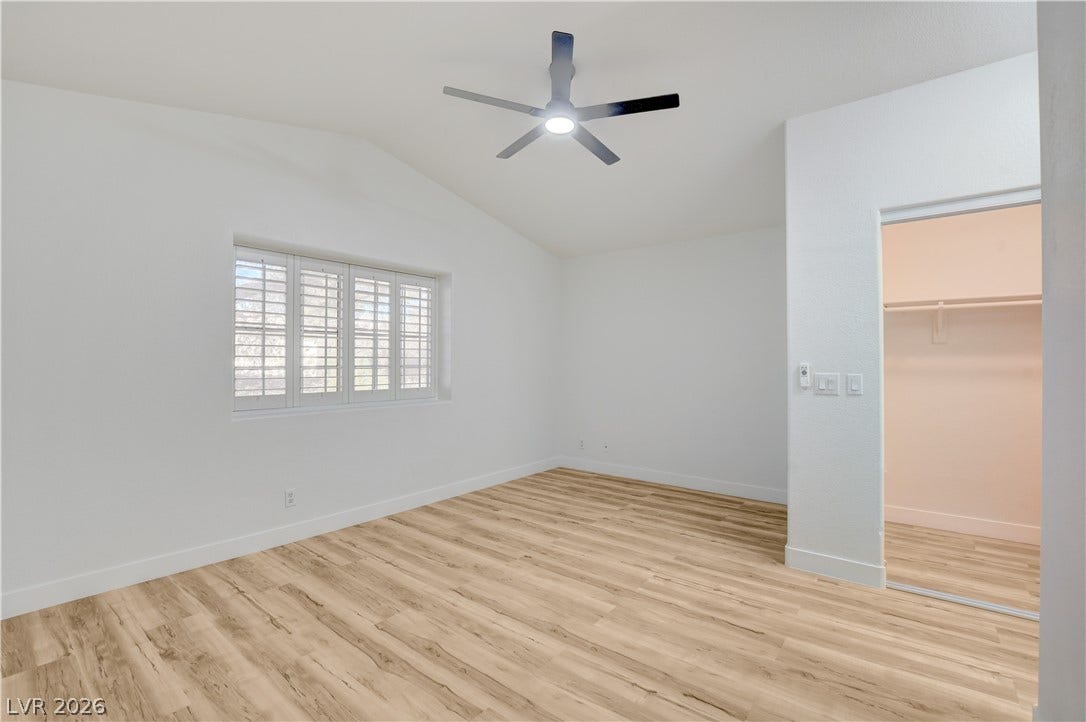3676 Renovah Street, #205, Las Vegas, NV 89129 Vaulted ceilings and wood-style flooring elevate this comfortable bedroom with an adjoining walk-in closet.