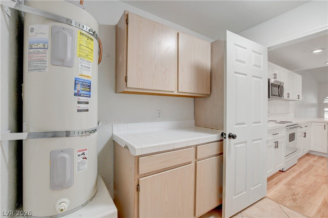 3676 Renovah Street, #205, Las Vegas, NV 89129 Practical storage cabinetry and a dedicated utility area open directly into the main kitchen.