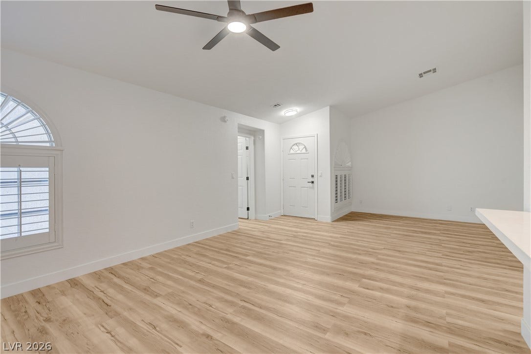 3676 Renovah Street, #205, Las Vegas, NV 89129 Laminate flooring sweeps across this open living area highlighted by a classic arched window.