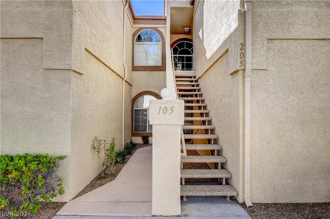 3676 Renovah Street, #205, Las Vegas, NV 89129 A concrete staircase leads to an upper-level entryway flanked by classic stucco walls.