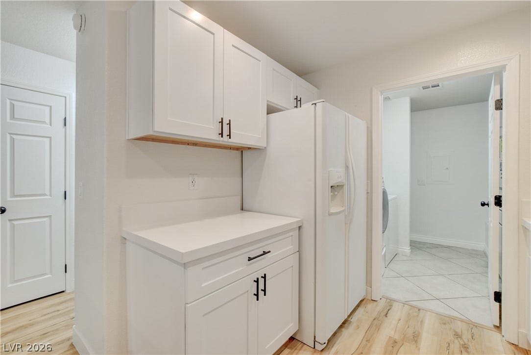 3676 Renovah Street, #205, Las Vegas, NV 89129 Crisp white cabinetry paired with durable solid-surface countertops adjoins a convenient laundry area.