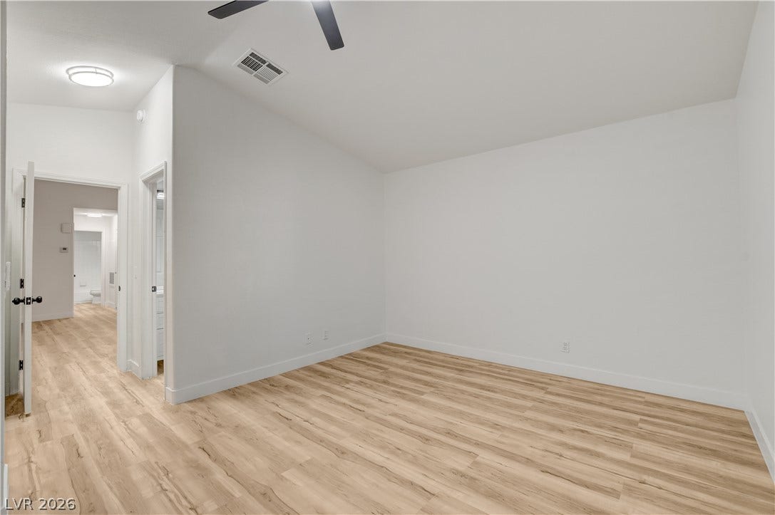 3676 Renovah Street, #205, Las Vegas, NV 89129 Warm wood flooring and clean white walls create a serene, minimalist backdrop in this room.