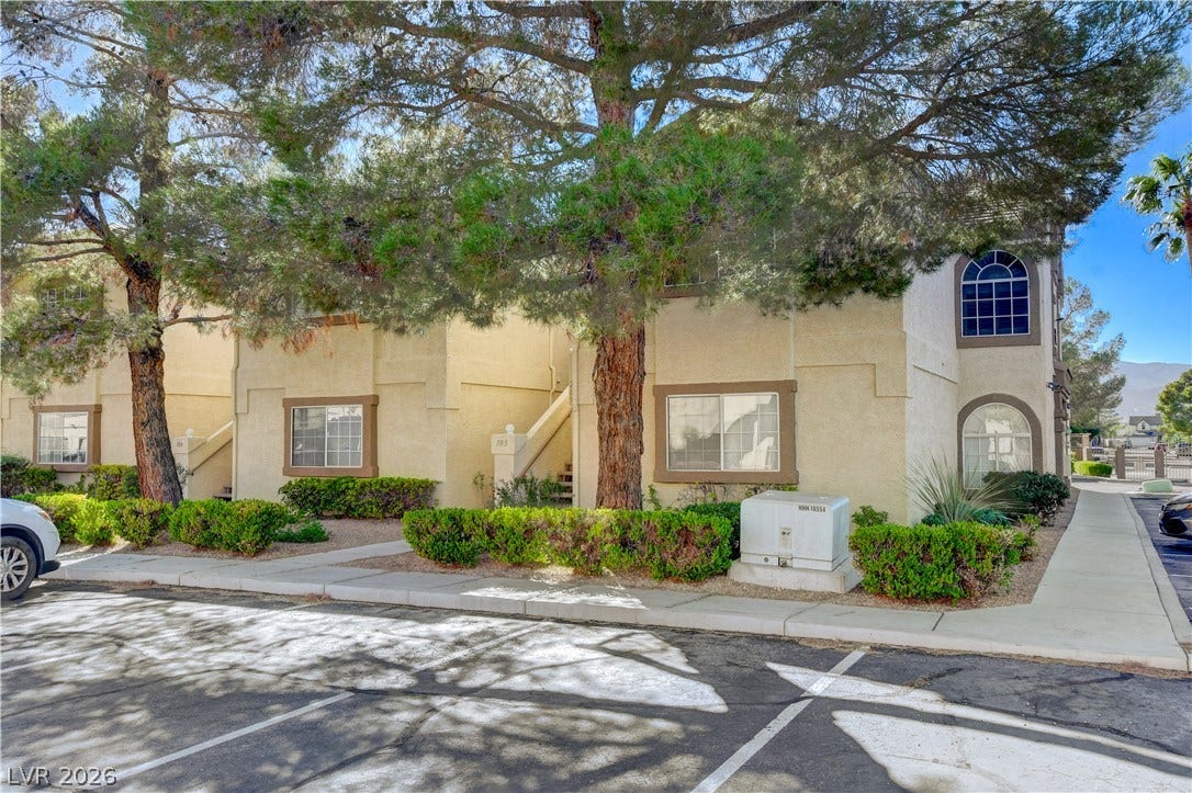 3676 Renovah Street, #205, Las Vegas, NV 89129 Mature trees shade the stucco exterior of this multi-level residential building.