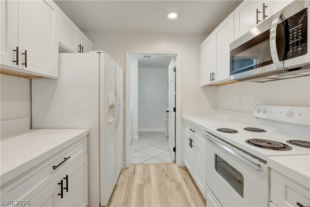 3676 Renovah Street, #205, Las Vegas, NV 89129 Crisp white cabinetry paired with durable solid-surface countertops organizes this streamlined culinary space.