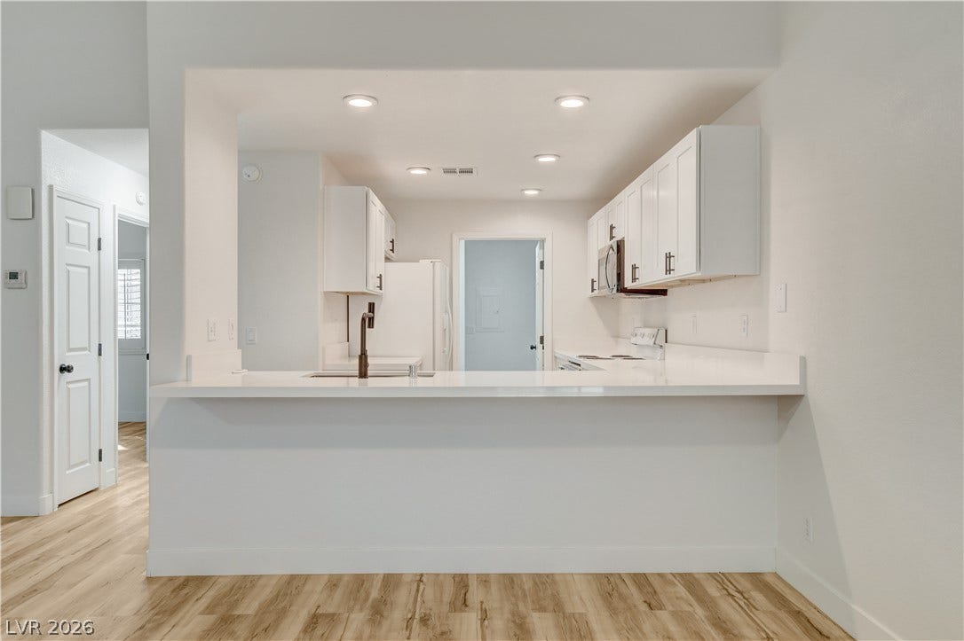 3676 Renovah Street, #205, Las Vegas, NV 89129 Smooth wood-look flooring anchors this open kitchen layout framed by recessed lighting.