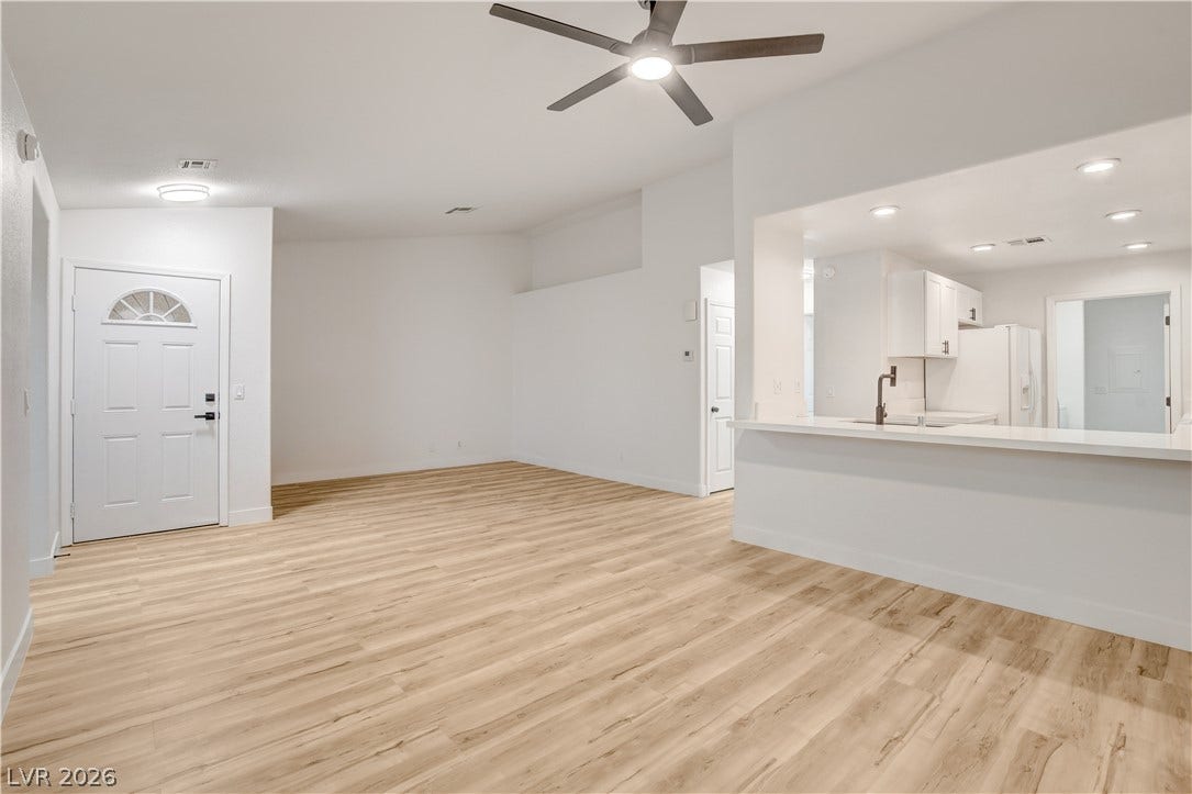 3676 Renovah Street, #205, Las Vegas, NV 89129 Gleaming wood-look floors unite the open-concept living area with a breakfast bar kitchen pass-through.