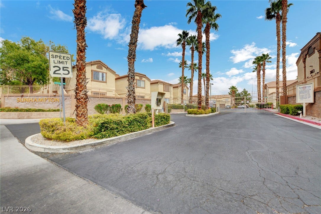 3676 Renovah Street, #205, Las Vegas, NV 89129 Secure gated entry welcomes residents home along a palm-lined paved drive.