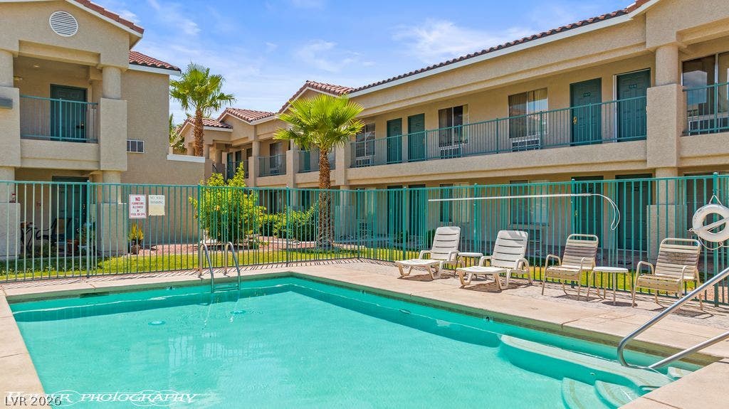100 Pulsipher Lane, #1205, Mesquite, NV 89027 Sun-drenched community courtyard features a sparkling swimming pool enclosed by secure metal fencing.
