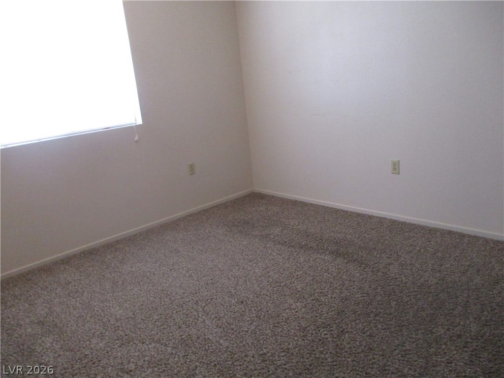 100 Pulsipher Lane, #1205, Mesquite, NV 89027 A spacious bedroom features neutral-toned carpeting and a large window providing ample natural light.