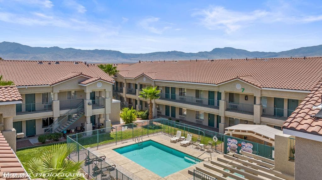 100 Pulsipher Lane, #1205, Mesquite, NV 89027 A sparkling community pool sits tucked against tile-roof residences under scenic mountain views.