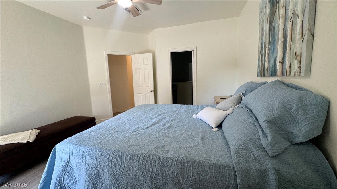 8304 Apple Glaze Avenue, #203, Las Vegas, NV 89145 An open and inviting bedroom features crisp white walls and smooth plank flooring.