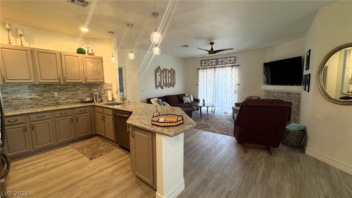 8304 Apple Glaze Avenue, #203, Las Vegas, NV 89145 An open floor plan seamlessly connects a spacious kitchen with a comfortable living area.