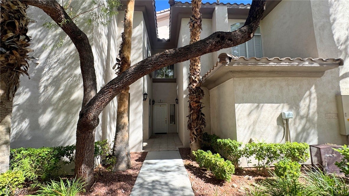 8304 Apple Glaze Avenue, #203, Las Vegas, NV 89145 Mature trees shade a welcoming concrete walkway leading directly to the private recessed entrance.