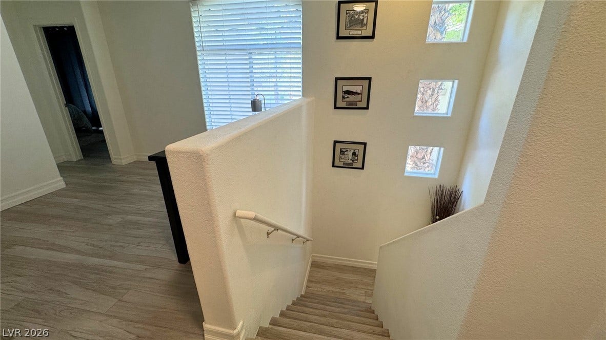 8304 Apple Glaze Avenue, #203, Las Vegas, NV 89145 Natural light streams through high windows over the central stairwell and wood-look flooring.