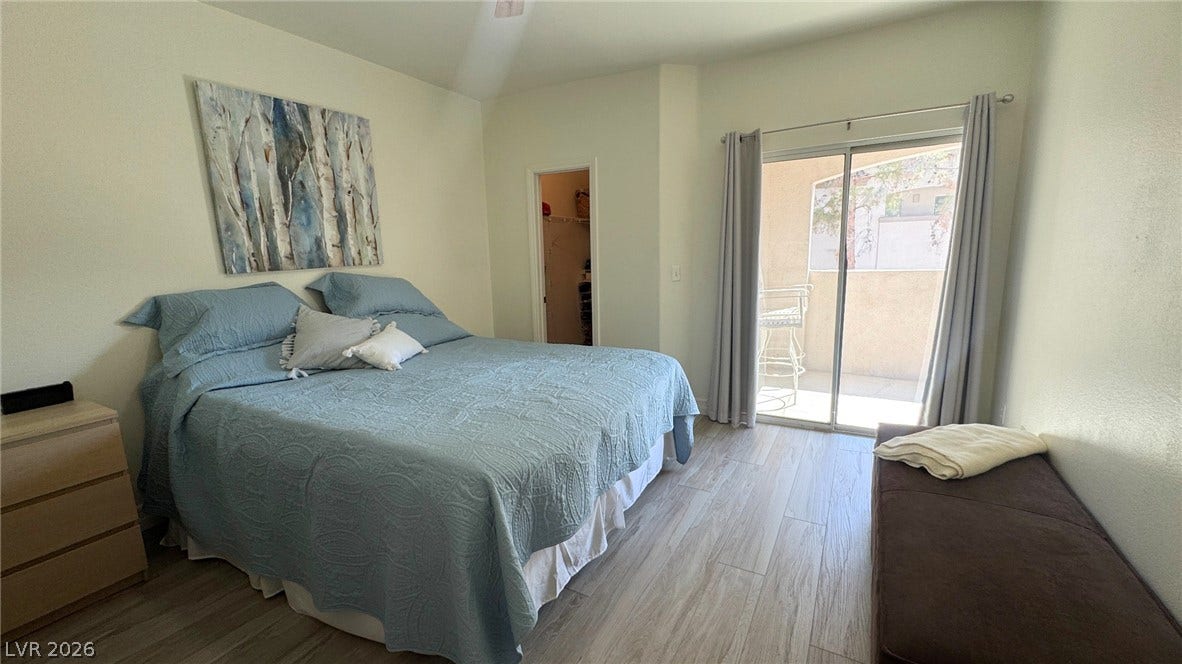 8304 Apple Glaze Avenue, #203, Las Vegas, NV 89145 Sliding glass doors open directly to a private balcony from this spacious bedroom.