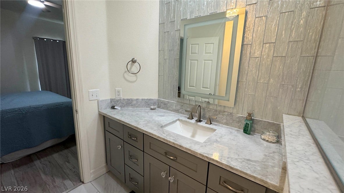 8304 Apple Glaze Avenue, #203, Las Vegas, NV 89145 An elegant vanity with stone counters and a vertical tile backsplash defines this updated space.