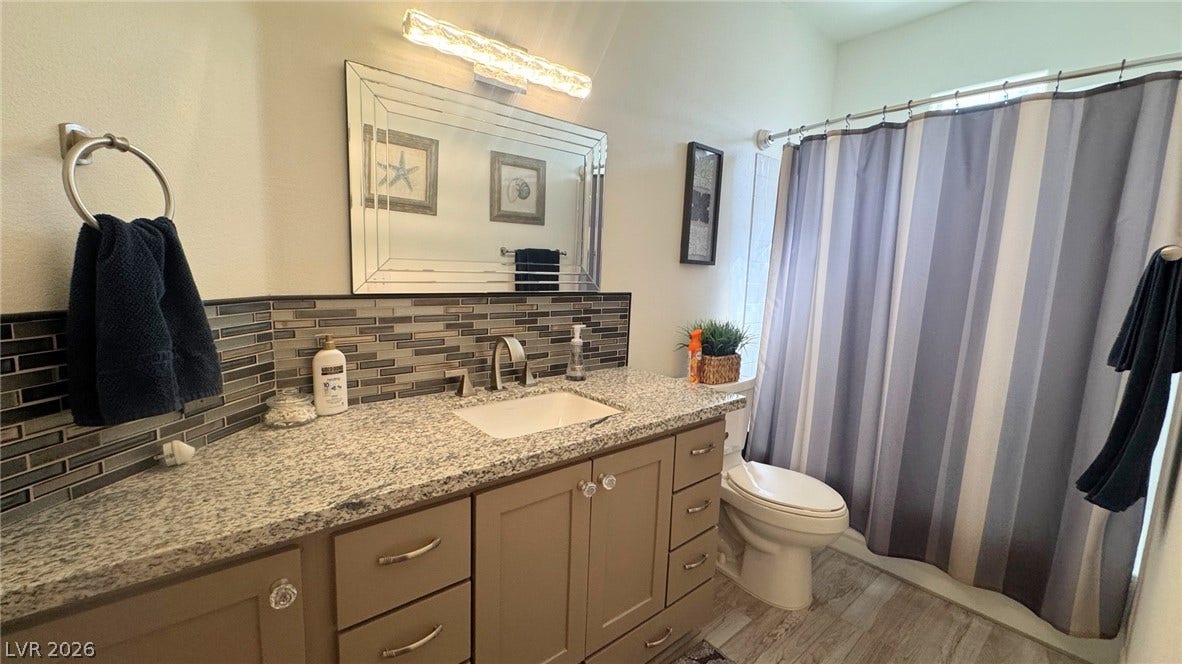 8304 Apple Glaze Avenue, #203, Las Vegas, NV 89145 Polished granite countertops and classic tile details define this comfortable bathroom space.