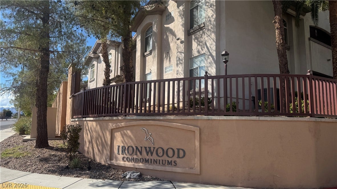 8304 Apple Glaze Avenue, #203, Las Vegas, NV 89145 Mature trees frame the multi-level stucco exterior and secure perimeter fencing of this residential community.