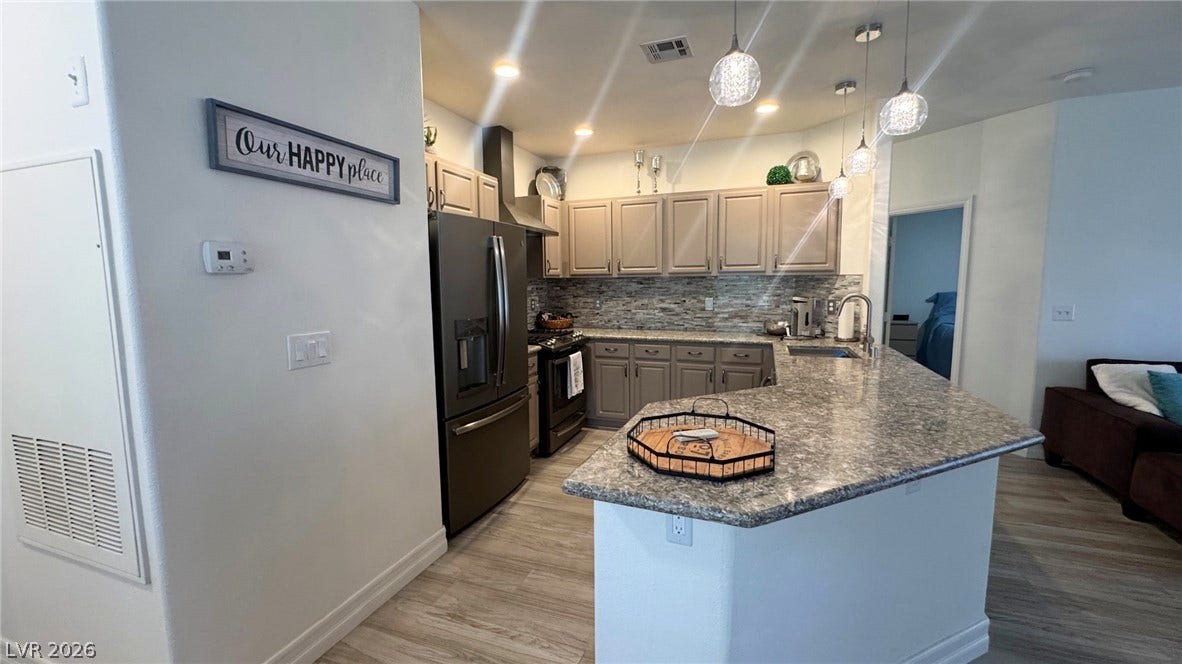 8304 Apple Glaze Avenue, #203, Las Vegas, NV 89145 Granite counters and an open breakfast bar anchor this modern kitchen layout.