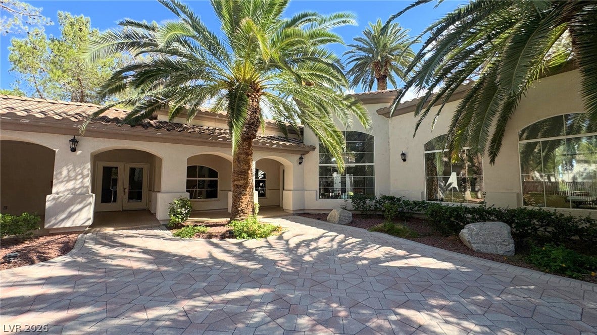 8304 Apple Glaze Avenue, #203, Las Vegas, NV 89145 Towering palm trees flank the elegant brick-paved entry of this classic stucco estate.