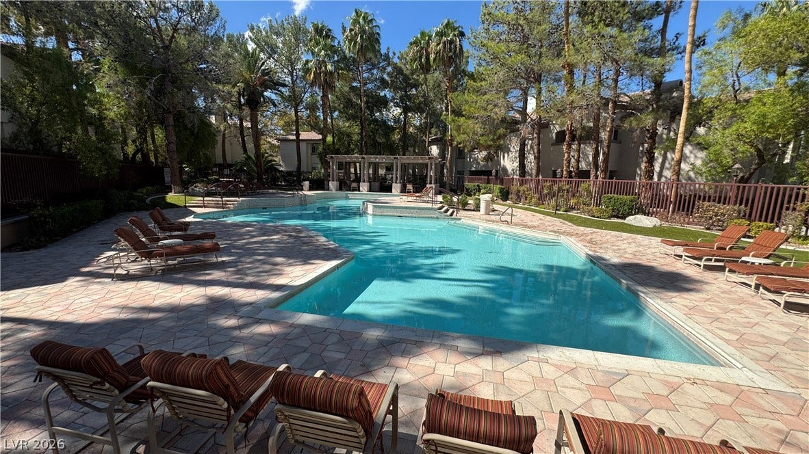 8304 Apple Glaze Avenue, #203, Las Vegas, NV 89145 Mature palms and leafy trees frame the spacious community swimming pool.