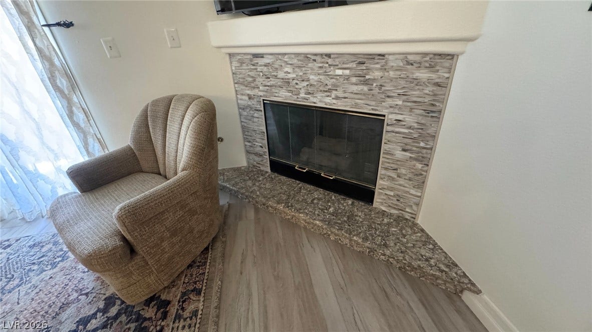 8304 Apple Glaze Avenue, #203, Las Vegas, NV 89145 An elegant corner fireplace with natural stone surrounds creates a cozy focal point.