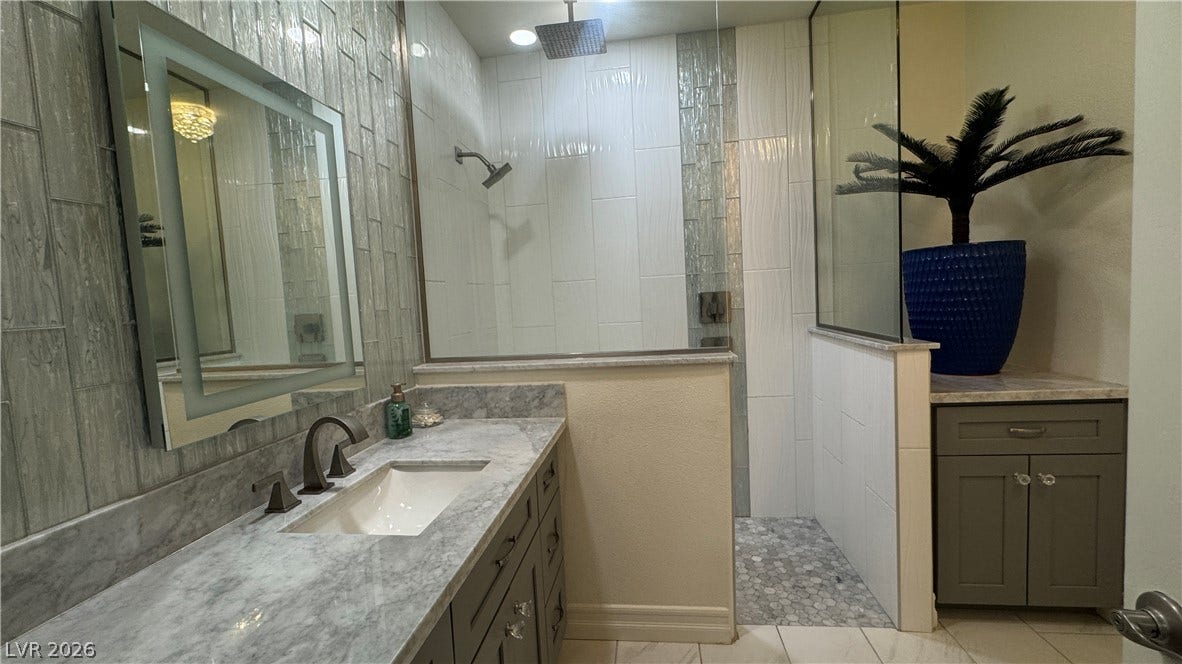8304 Apple Glaze Avenue, #203, Las Vegas, NV 89145 Polished stone vanity tops and a walk-in tile shower define this modern bathroom retreat.