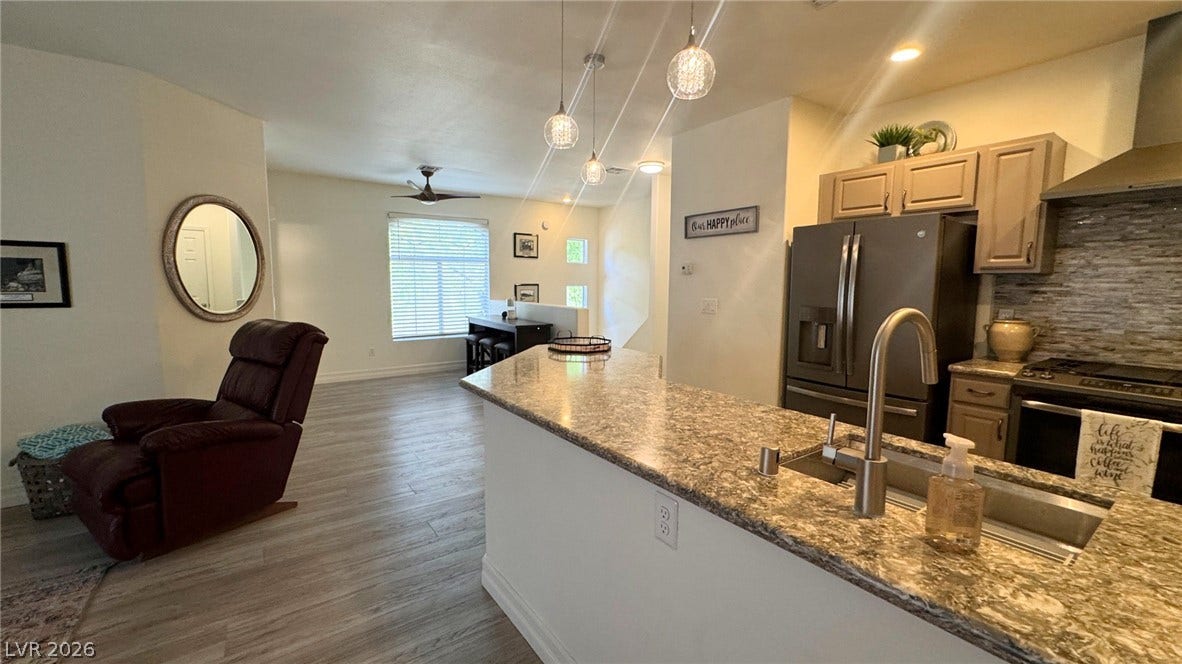 8304 Apple Glaze Avenue, #203, Las Vegas, NV 89145 An open floorplan seamlessly connects the stone counters of the kitchen to the main living area.