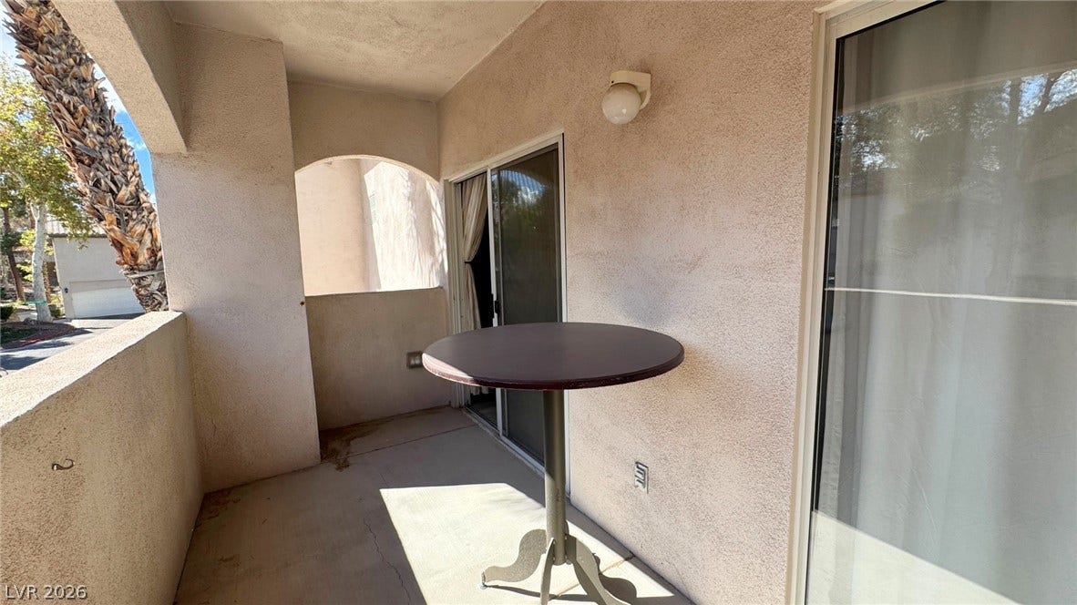 8304 Apple Glaze Avenue, #203, Las Vegas, NV 89145 A private covered balcony features classic stucco walls and concrete flooring.