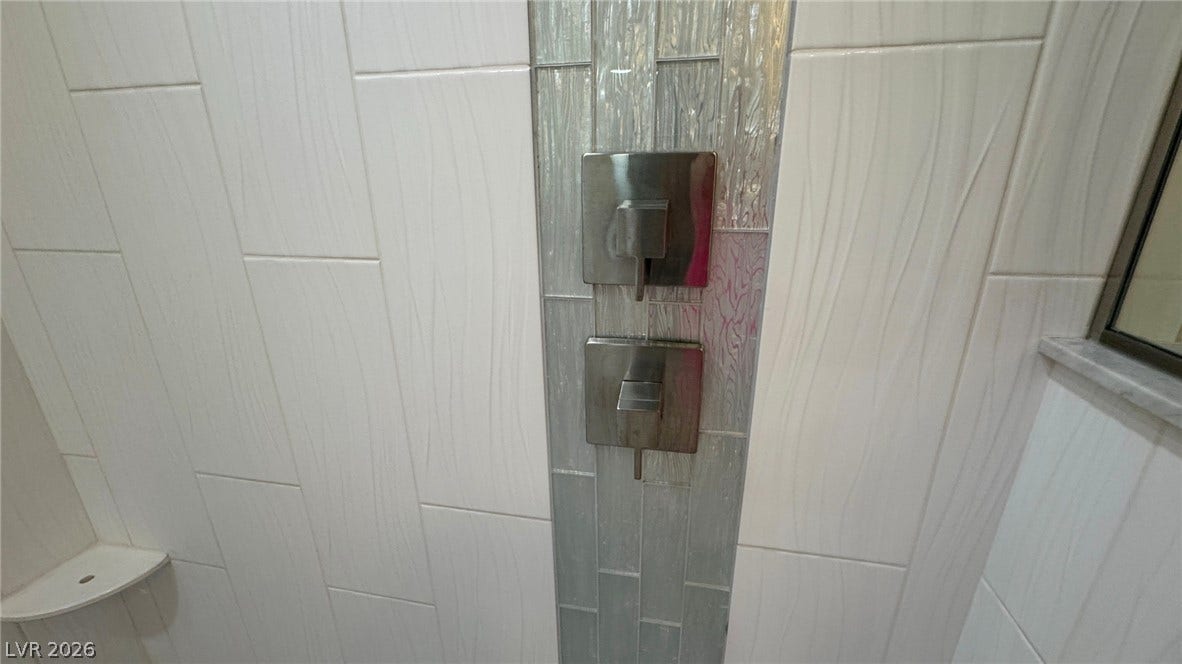 8304 Apple Glaze Avenue, #203, Las Vegas, NV 89145 A vertical accent of shimmering mosaic tile enhances the tiled walk-in shower design.