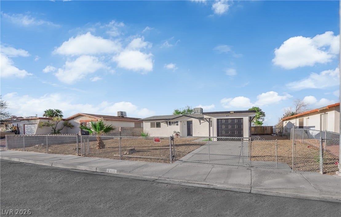 419 Scenic Drive, Henderson, NV 89002 A classic single-story home featuring a fenced front yard, gravel landscaping, and an attached garage.
