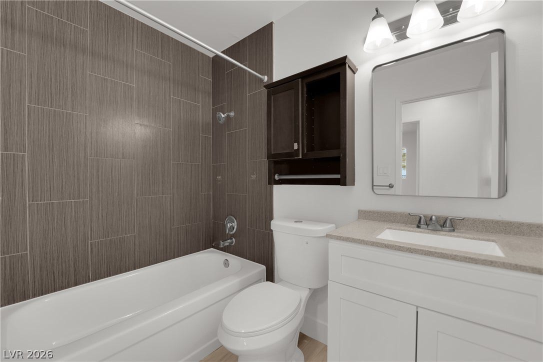 419 Scenic Drive, Henderson, NV 89002 A contemporary vanity and tub surrounded by modern vertical tile highlight this sleek bathroom.