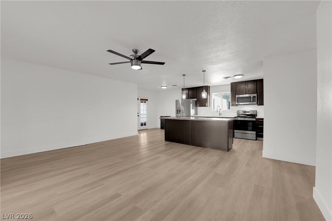 419 Scenic Drive, Henderson, NV 89002 Smooth wood floors flow seamlessly through this open-concept layout connecting the kitchen and living areas.