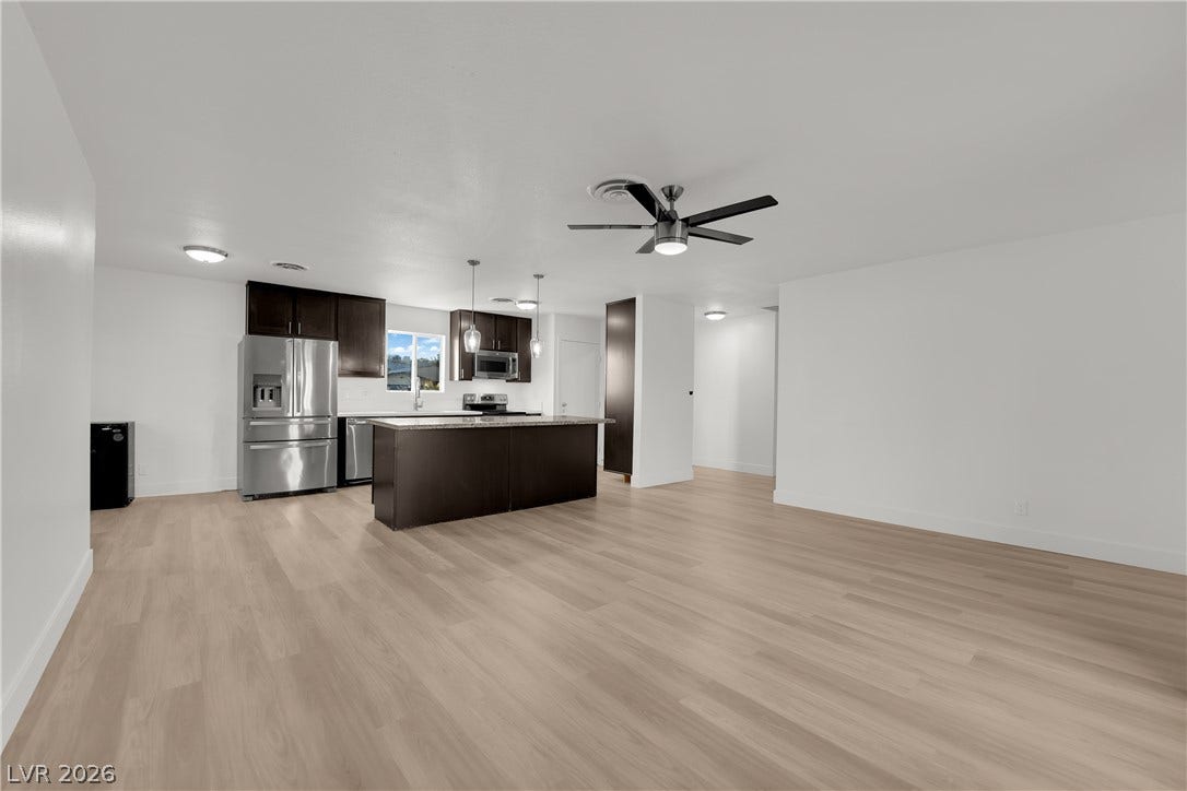 419 Scenic Drive, Henderson, NV 89002 Smooth wood floors flow effortlessly from the spacious living area directly into the modern kitchen.